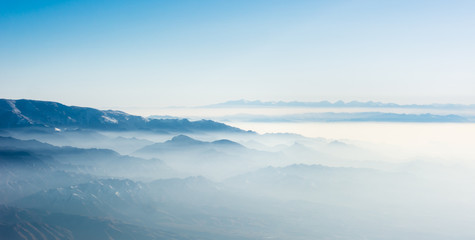 Fototapeta na wymiar Fog covered Tian Shan mountain range in China near Ürümqi