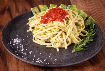 Pasta spaghetti with zucchini, basil, cream and cheese on wooden table. Vegetarian vegetable pasta. Zucchini noodles.