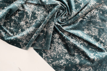 Blue and silver velvet sample on the table. The designer workplace concept. Freelance fashion femininity workspace in flat lay style