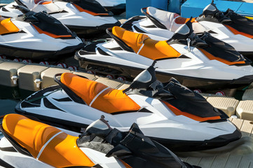 Colored jet skis parked on floating watercraft pontoon