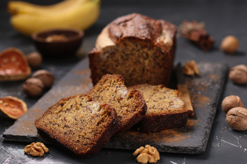 Homemade banana bread with walnut and cinnamon on a dark background