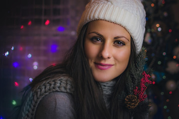 Close-up portrait of beautiful, young woman with white hat, holding a branch