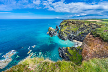 View of the South Devon coast, England, in the summer with clear waters, blue sky and grass. - obrazy, fototapety, plakaty