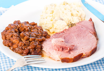 Ham Dinner with Sweet Baked Beans and Potato Salad on Blue Gingham Country Setting