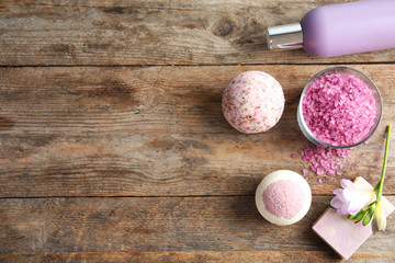 Flat lay composition with bath bombs, toiletries and space for text on wooden background