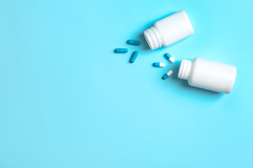 Flat lay composition with bottles, pills and space for text on color background