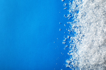 White snow and space for text on color background, top view