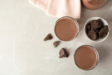 Flat lay composition with glasses of tasty chocolate milk and space for text on light background. Dairy drink