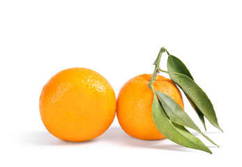 Tasty ripe tangerines with leaves on white background