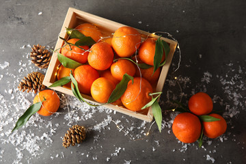 Christmas composition with ripe tangerines and artificial snow on grey background, flat lay