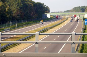 View from the viaduct over the highway. Cars driving in the background.