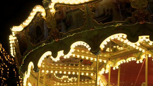 Fascinating flashing lights dark night sky illumination of vintage merry go round fair carousel ferris wheel at carnival