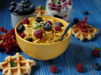 Healthy breakfast with corn flakes, berries, waffle and milk
