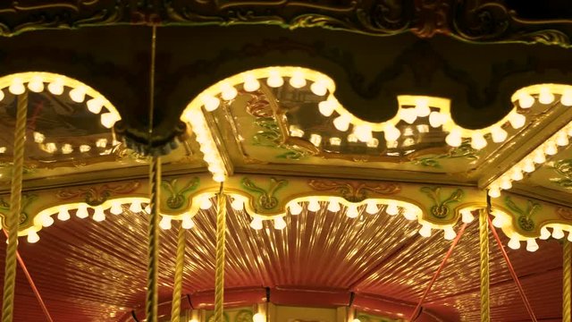 Fascinating flashing lights dark night sky illumination of vintage merry go round fair carousel ferris wheel at carnival