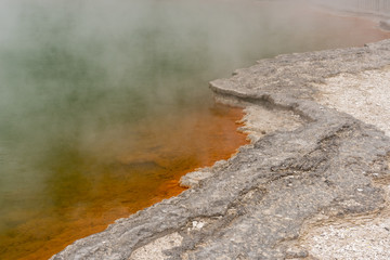 The edge of the Champagne Pool at the Wai-O-Tapu geothermal area showing the orange orpiment and stibnite deposits.