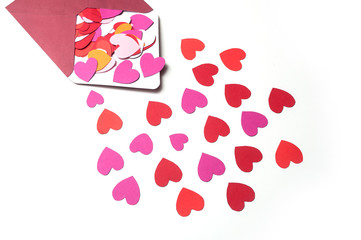 closeup of paper heart falling from envelope on white background - valentine's day concept
