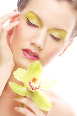 young woman with bright make up holding orchid