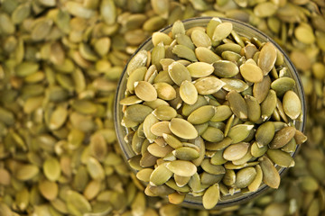 Peeled raw pumpkin seeds in a bag. Close-up. The background is blurred.
