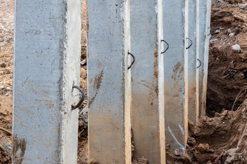 Close-concrete pillars installed in a trench dug soil.