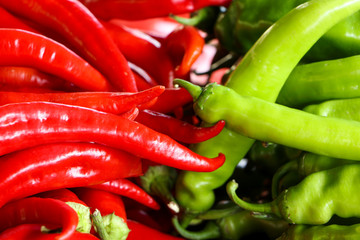 Pods of red and green bitter pepper. Harvest vegetables on the market counter. Close-up.