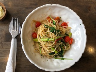 Spaghetti al dente aglio olio with baby tomatoes and vegetables