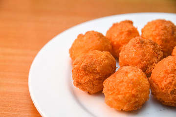 Cheese balls, Breaded mozzarella cheese balls with tomato in white dish on wood blackground
