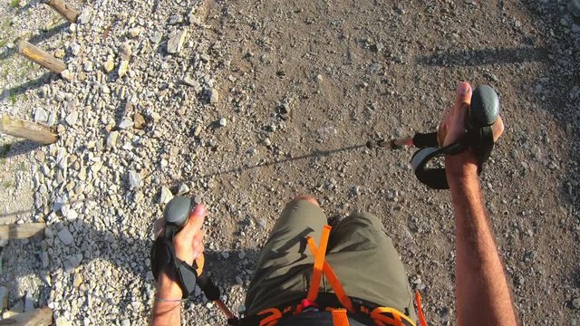 POV man hiking in the mountain with boots and trekking poles