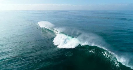 Aerial view of large blue ocean waves crashing on sunny day  - Powered by Adobe