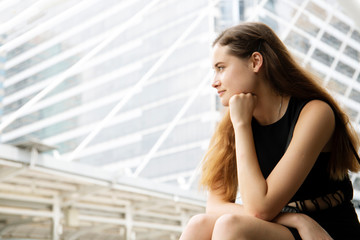 Beautiful white woman sitting relaxation and thinking on street..