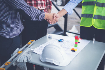 engineers and businessman shaking hands for make an agreement in investment about construction project. success dealing greeting and partner concept.