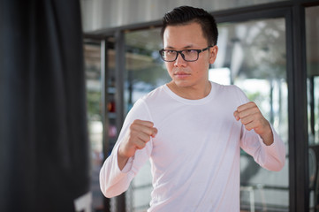 Fototapeta premium sportsman practicing boxing in gym. he punch the punching bag.