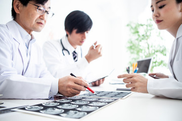 Obraz premium レントゲン写真を見ながら今後の治療について話し合う医師