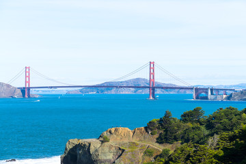 The view of golden gate bridge in Lands end at San Francisco- San Francisco. summer , cloud , rock , sea, plant.