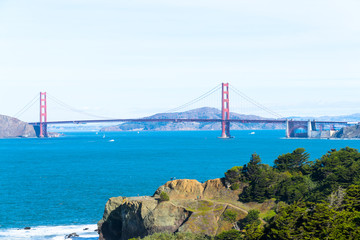 The view of golden gate bridge in Lands end at San Francisco- San Francisco. summer , cloud , rock , sea, plant.