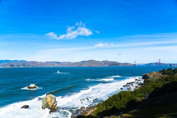 The view of golden gate bridge in Lands end at San Francisco- San Francisco. summer , cloud , rock , sea, plant.