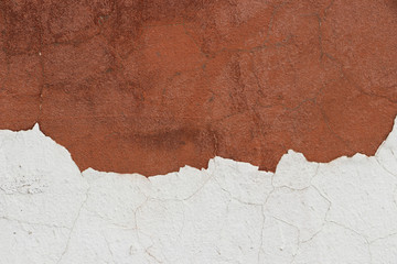 Cracked white plaster on a dark wall. Texture. Close-up.