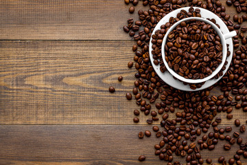 Coffee concept. Roasted beans on wooden background top view copy space