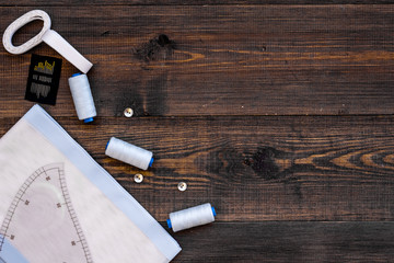 Tailor work place with thread, fabric. Sewing as hobby. Wooden background top view space for text