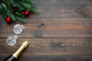 New Year celebration with spruce branch, champagne and glasses wooden table background top view mock up