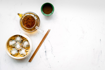 Dinner in Chinese restaurant with dim sum, sticks and herbal tea on marble background top view...