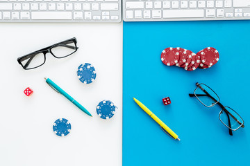 Workplace with stacks of chips to win business competition. Monopoly strategy. White and blue desk background top view