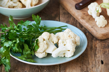 Raw cauliflower and fresh parsley on a plate