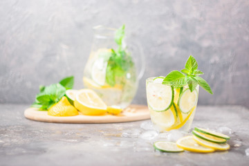Refreshing non-alcoholic cocktail Mahito with lime slices on a gray background. Summer drink lemonade with mint. Selective focus. Copy space. Place for text and design.