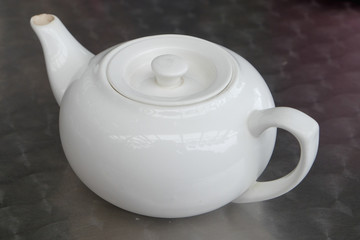 White teapot on the table  at the restaurant