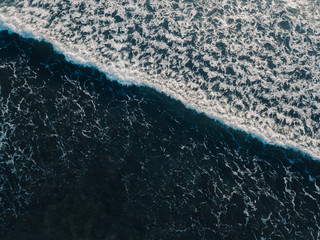 Sea aerial view, top view, amazing nature background. Blue color of the water and beautiful bright. Azure beach with turquoise waves and clear water of ocean on sunny day. Sea view from flying drone