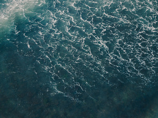 Fototapeta premium Aerial view beautiful of sea waves from drone. Stock image picture of blue color ocean water, wave, sea surface. Top view on turquoise waves, clear water surface texture. Top view, amazing nature