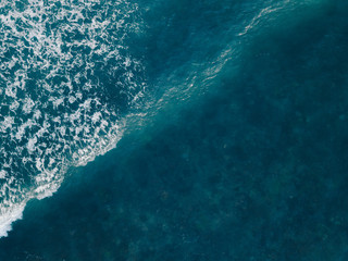 Aerial view beautiful of sea waves from drone. Stock image of blue color of ocean water, sea surface. Top view on turquoise waves, clear water surface texture.  Top view, amazing nature background