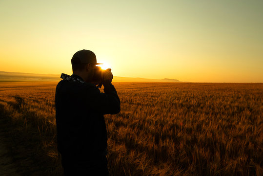 Man take a photo in sunrise in field