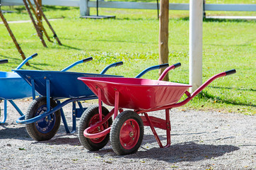 wheelbarrow carts colorful material on the floor.