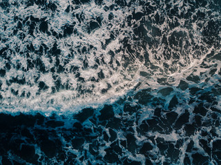 Aerial view beautiful of sea waves from drone. Stock image of blue color of ocean water, sea surface. Top view on turquoise waves, clear water surface texture.  Top view, amazing nature background